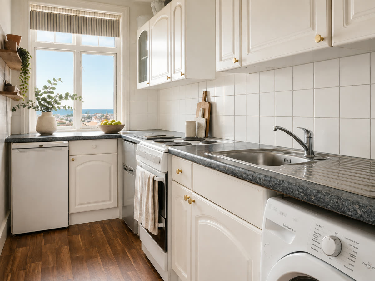 Galley kitchen with a window looking out to sea
