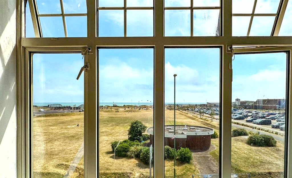 View south through the lounge window over the seafront green to the English Channel